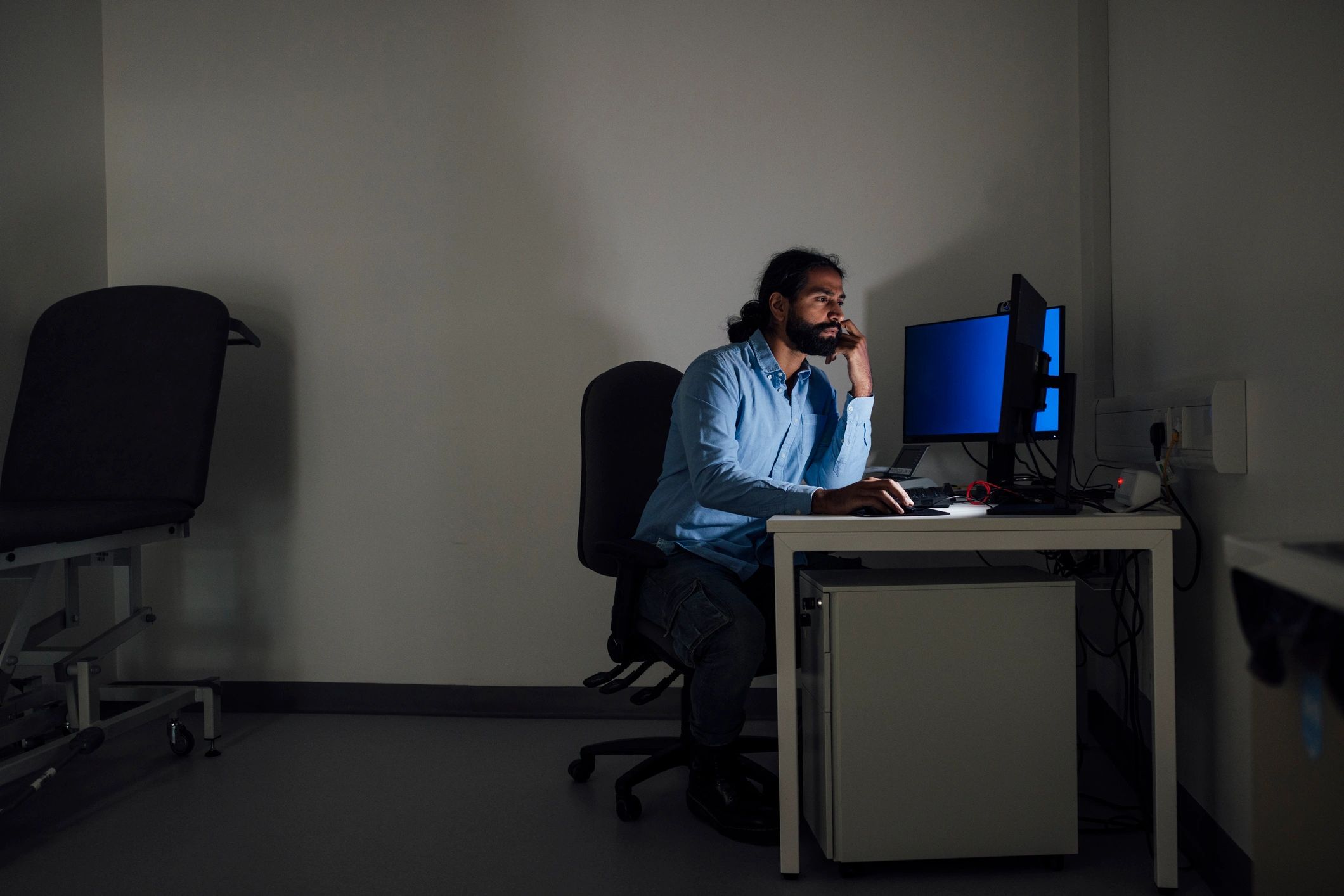 Professional working at a computer in a low-light environment